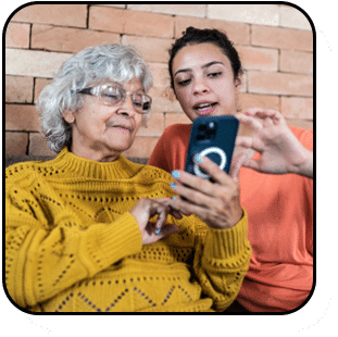 Young woman helping her grandmother with her phone